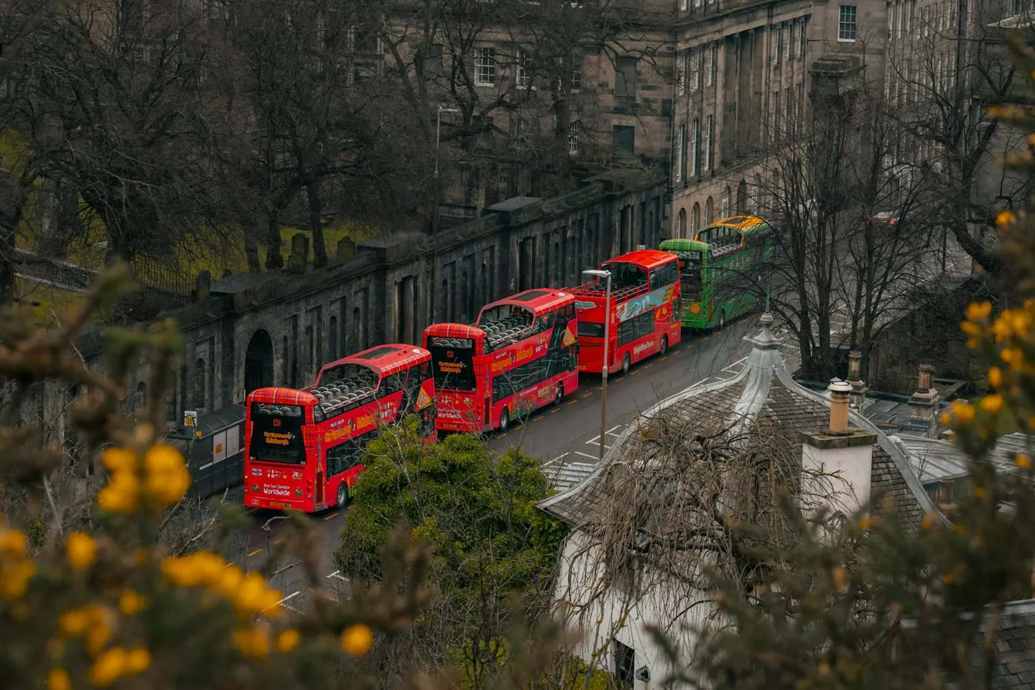 Rode hop-on hop-off bussen op een rij in een straat in Edinburgh